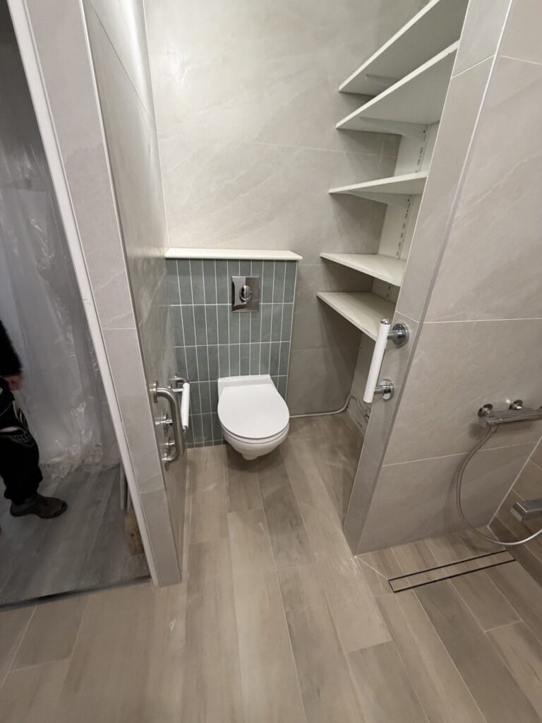 Douche et WC suspendu avec niches de rangement dans une petite salle de bain rénovée