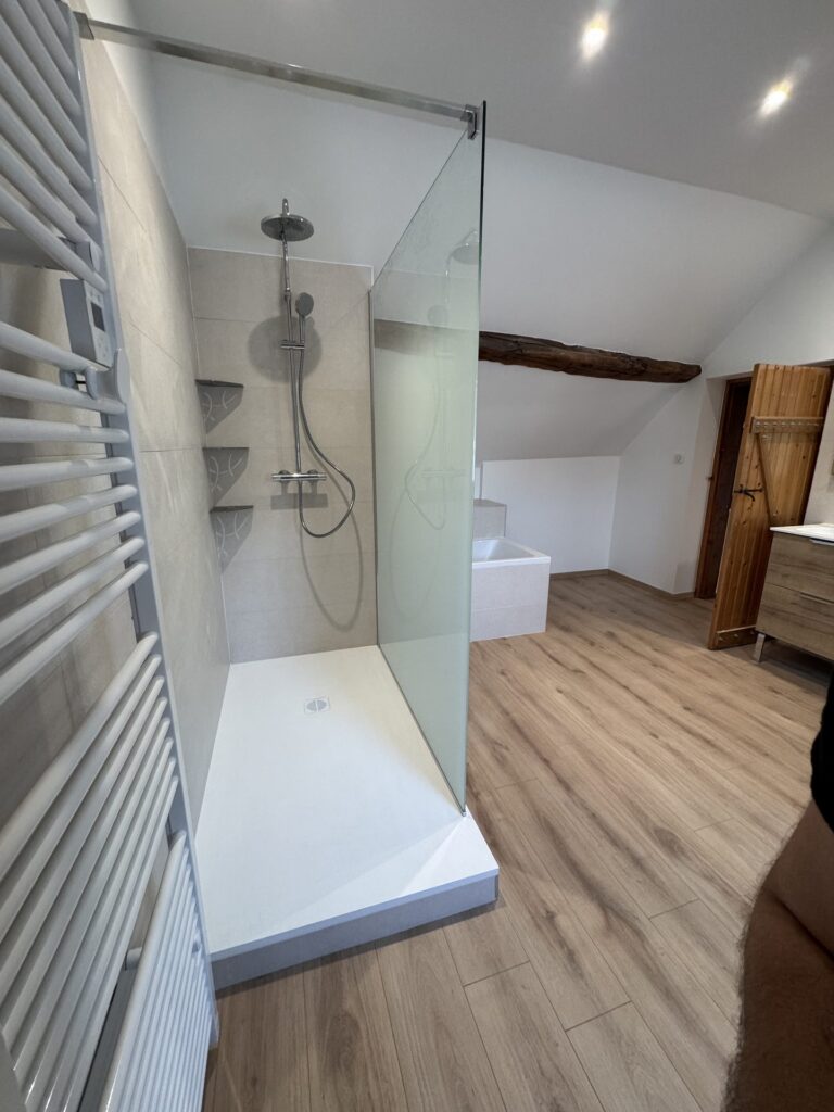 Espace douche et sèche-serviettes dans une salle de bain sous combles rénovée près de Dijon