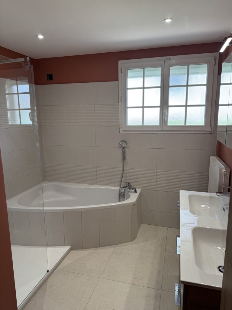 Baignoire d'angle et mur terracotta dans une salle de bain rénovée près de Dijon